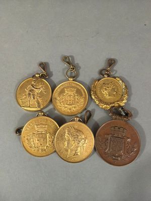 four gold medals are shown on a white surface