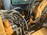 l'arrière d'un engin de chantier auquel sont raccordés plusieurs tuyaux