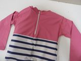 pink and blue striped jacket with zippered sleeves on a white surface