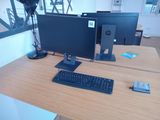 a desk with two monitors and a keyboard on it