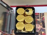 a box of gold coins sitting on top of a table
