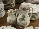 de nombreuses assiettes et tasses sur la table, ainsi qu'un vase et un pichet