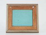 an old picture frame with a blue background on a white surface