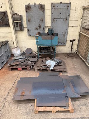 many pieces of metal sitting on the floor in the garage