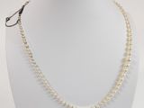un gros plan sur un collier blanc porté par un mannequin