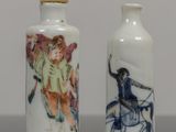 two vases with different designs on them sitting on a table