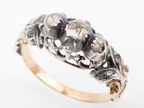 a close up of a gold and diamond ring on a white background