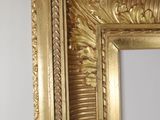 an image of a gold framed mirror on a wall in a room