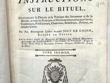 an old book on a table with a bunch of books in the background