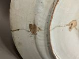 a close up of a white plate with a crack in it