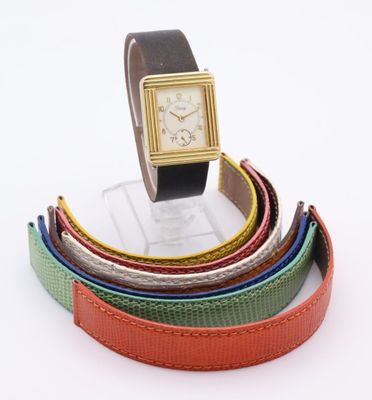 an image of a wrist watch sitting on top of a stack of belts