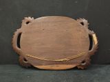 an old wooden cutting board with a handle on a black surface
