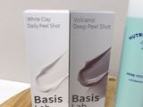 three tubes of white clay on a table next to a box of white clay
