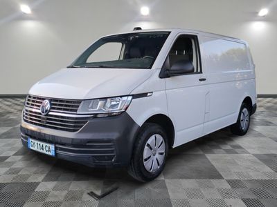Une camionnette blanche est garée dans une pièce au sol en damier.