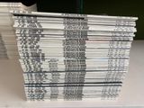 a lot of books stacked on top of each other on a table