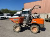 a small orange tractor parked in front of a building