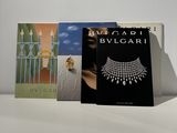 three books on a table with a white background and a black cover