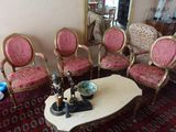plusieurs chaises et une table basse dans une pièce où se trouve un miroir