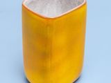 une tasse jaune bordée de blanc, posée sur une surface bleue