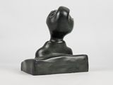 black sculpture of a hand on a block on a white surface