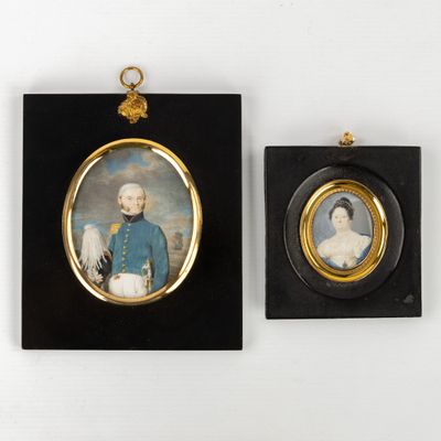 deux portraits encadrés représentant un homme et une femme, accrochés au mur