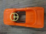 an orange toy car with a steering on a wooden floor