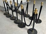 un ensemble de poteaux de délimitation noirs et dorés, entourés d'une corde