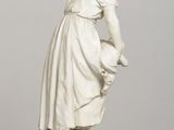 a statue of a woman with a basket on a table