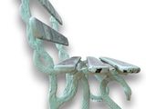 a sculpture of a dragon on a bench made out of metal