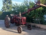 un tracteur rouge garé sur le bord de la route