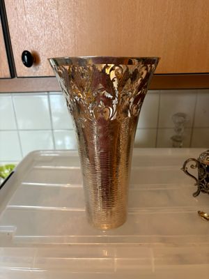 un vase en argent posé sur un comptoir blanc