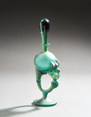 a glass bottle that has a green design on it