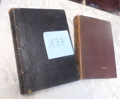 deux vieux livres posés sur une table, sur laquelle se trouve un mot