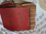 un livre rouge posé au sommet d'une pile de livres