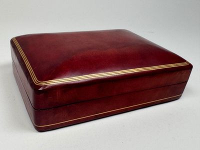 a red leather box with gold trimming on the sides