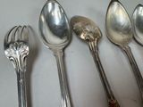 five spoons and a fork sitting on a table