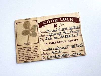 an old business card with a four leaf clover on it