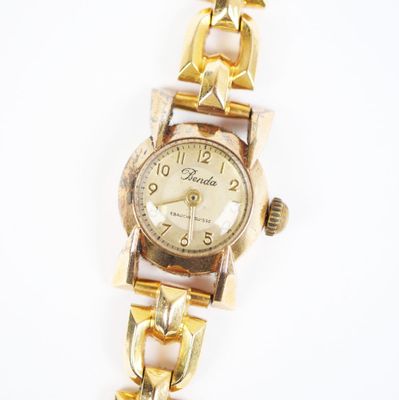 une image d'un gros plan d'une montre-bracelet sur une surface blanche