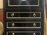 une commode noire et dorée surmontée d'une horloge