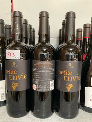 plusieurs bouteilles de vin sont alignées sur une étagère