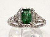 une photo d'une bague ornée d'une pierre verte entourée de diamants