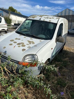 une camionnette blanche qui a été vandalisée dans une cour