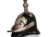 an old helmet with a metal decoration on top of a white surface