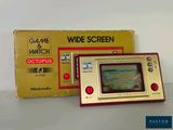 un Game & Watch posé sur la table à côté de la boîte