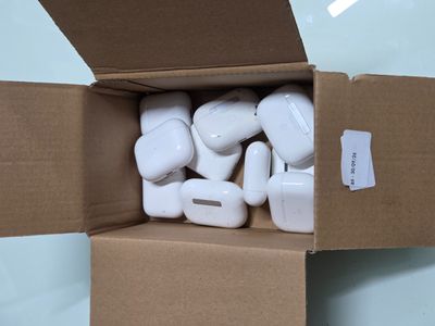 une boîte en carton remplie d'AirPods blancs, posée sur une table