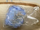 a basket with a blue and white checkered shirt inside of it