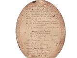 un vieux bout de papier sur lequel sont inscrits des caractères, reposant sur une surface blanche