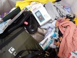 a pile of clothes and other items in a suitcase