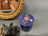 a dog statue next to a box and a mirror