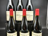 six bouteilles de vin sont alignées sur un comptoir